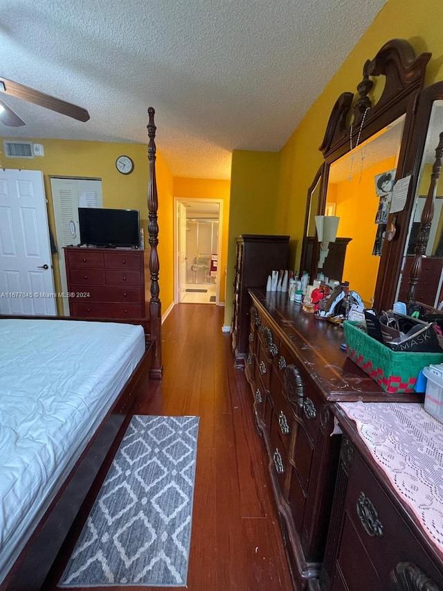 bedroom featuring dark wood-type flooring, ceiling fan, and a textured ceiling