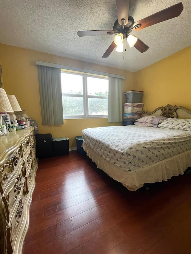 bedroom with a textured ceiling, dark hardwood / wood-style floors, and ceiling fan