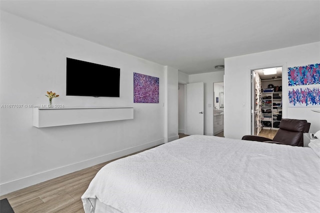 bedroom featuring hardwood / wood-style floors, ensuite bathroom, a spacious closet, and a closet