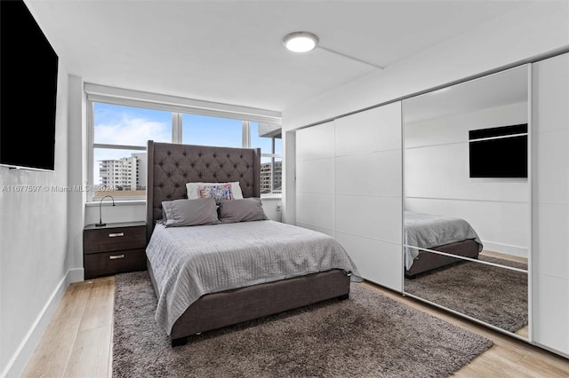 bedroom with light hardwood / wood-style floors and multiple windows