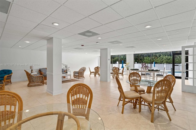 dining room with light tile patterned flooring, floor to ceiling windows, a wealth of natural light, and decorative columns