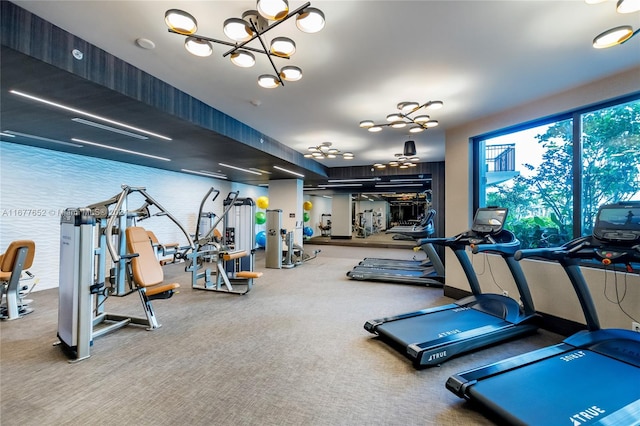 gym featuring an inviting chandelier and carpet