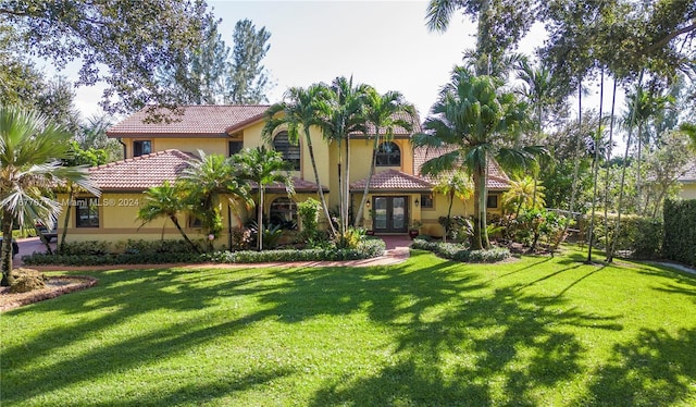 mediterranean / spanish home with french doors and a front lawn