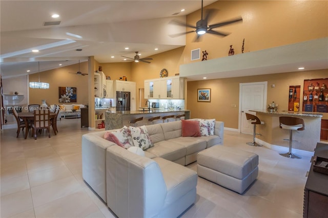 living room featuring high vaulted ceiling and light tile patterned flooring