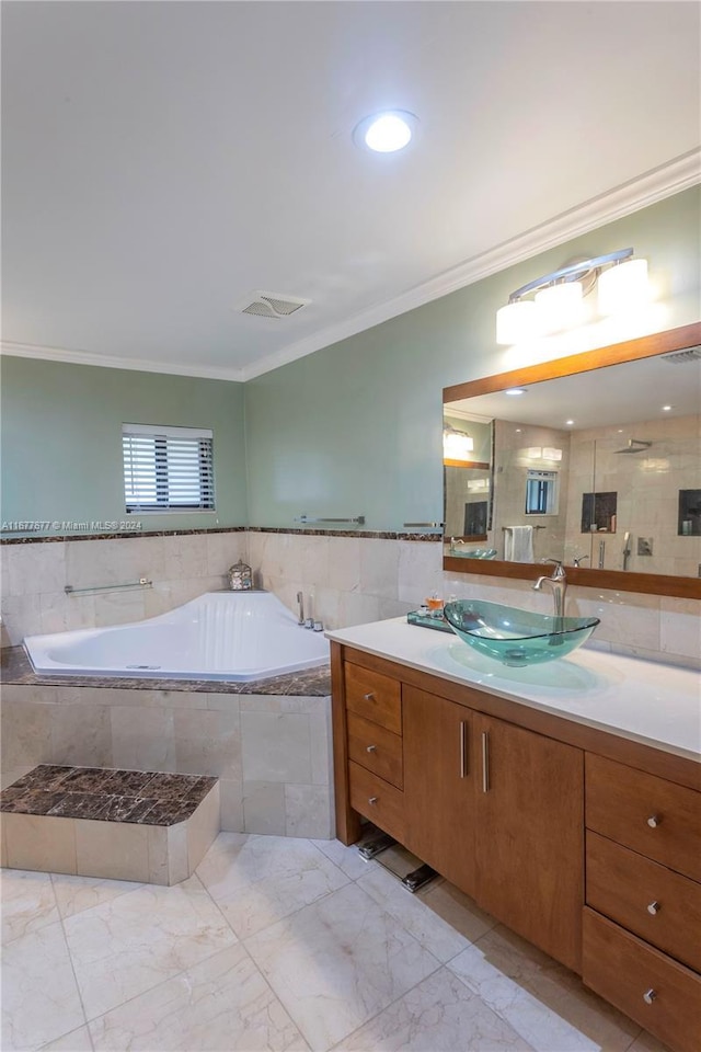 bathroom with tiled bath, crown molding, and vanity