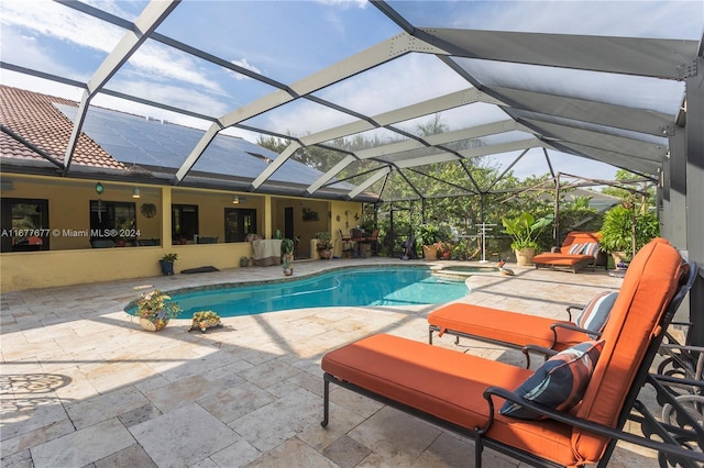 view of swimming pool featuring an in ground hot tub, a patio area, and a lanai