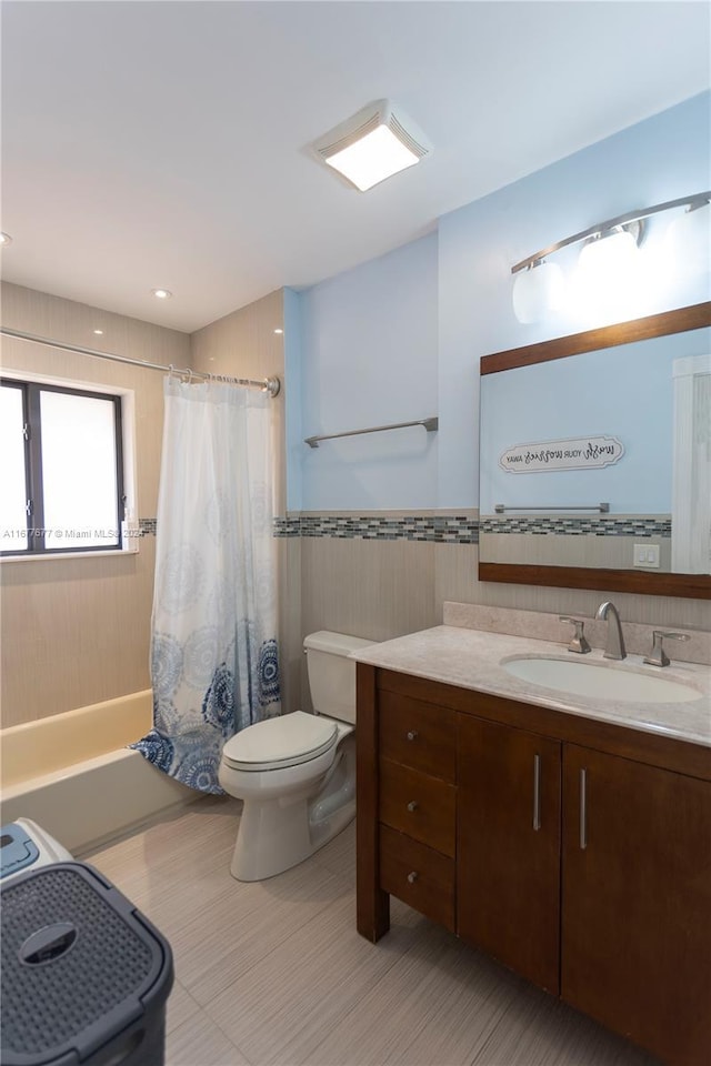 full bathroom featuring vanity, toilet, tile walls, and shower / tub combo with curtain