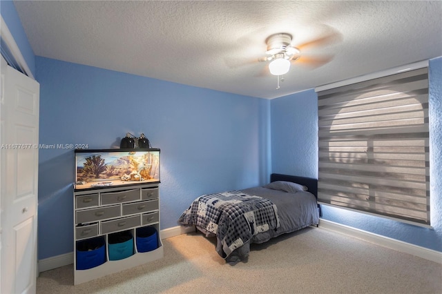 carpeted bedroom featuring ceiling fan, a textured ceiling, and a closet