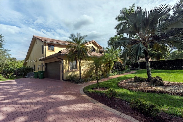 view of side of home featuring a garage and a lawn