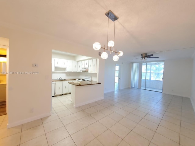 kitchen featuring kitchen peninsula, white range with electric stovetop, light tile patterned flooring, white cabinets, and ceiling fan with notable chandelier