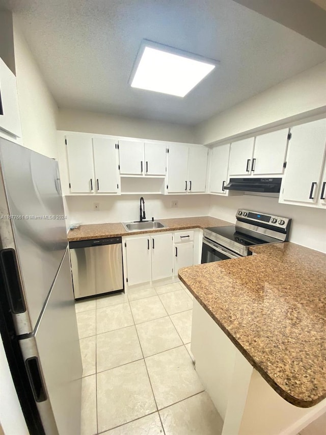 kitchen with stainless steel appliances, extractor fan, sink, and white cabinets