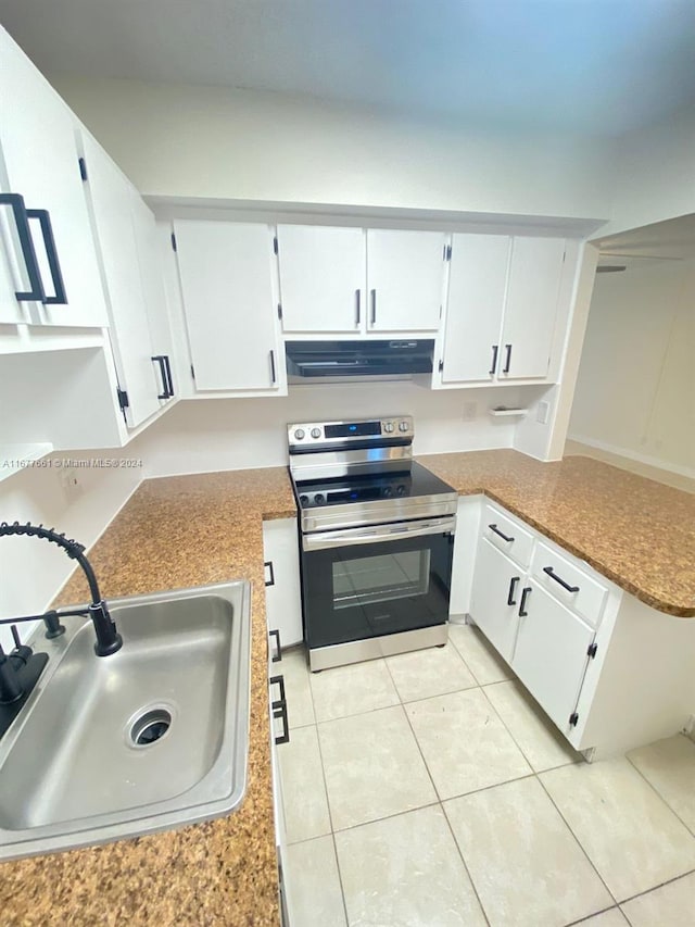 kitchen featuring white cabinets, light tile patterned floors, extractor fan, stainless steel range with electric stovetop, and sink