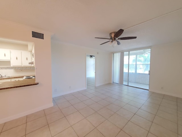 tiled empty room featuring ceiling fan