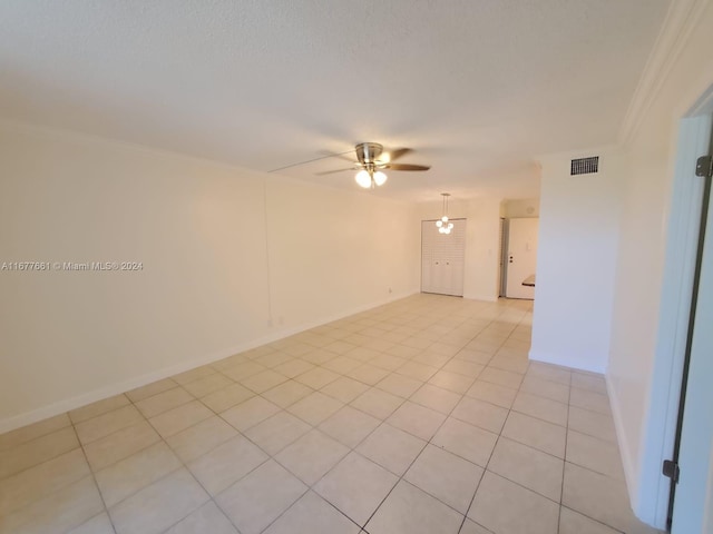 spare room with ornamental molding, light tile patterned floors, and ceiling fan