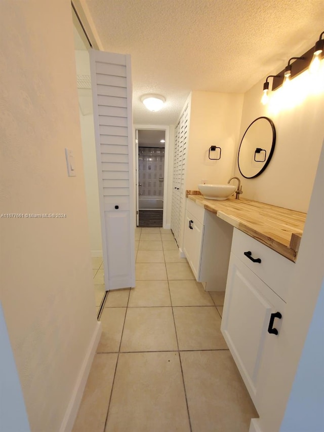 bathroom featuring vanity, a textured ceiling, and tile patterned flooring