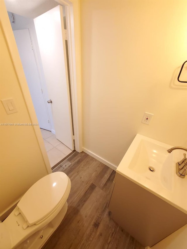 bathroom with toilet and hardwood / wood-style floors