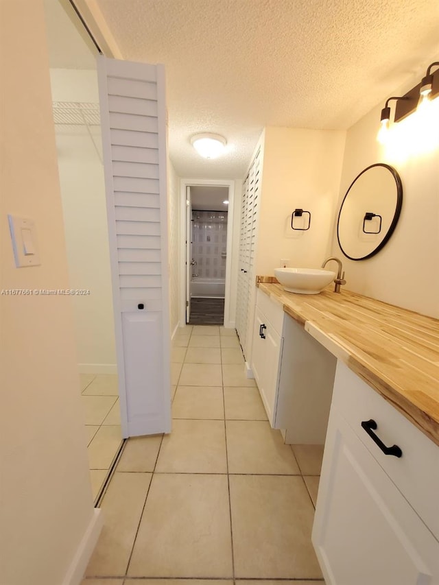 bathroom featuring vanity, a textured ceiling, and tile patterned floors