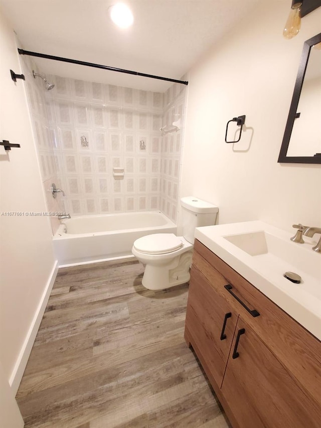 full bathroom with vanity, tiled shower / bath combo, hardwood / wood-style flooring, and toilet