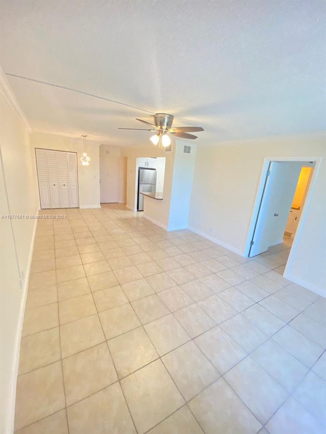 spare room featuring ornamental molding, light tile patterned flooring, and ceiling fan