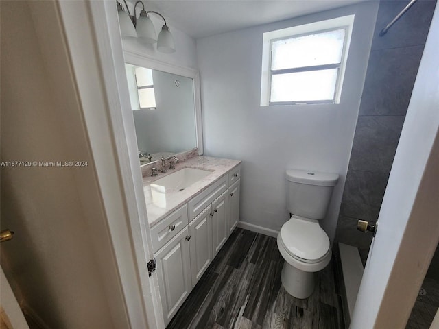 bathroom featuring vanity, toilet, hardwood / wood-style flooring, and walk in shower