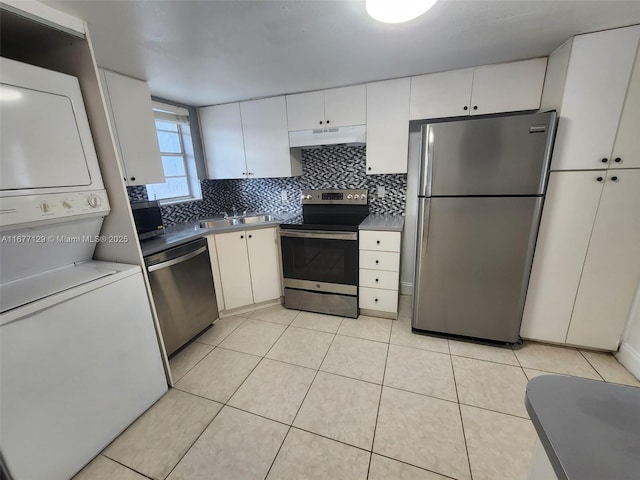 kitchen with white cabinetry, backsplash, stainless steel appliances, and stacked washing maching and dryer