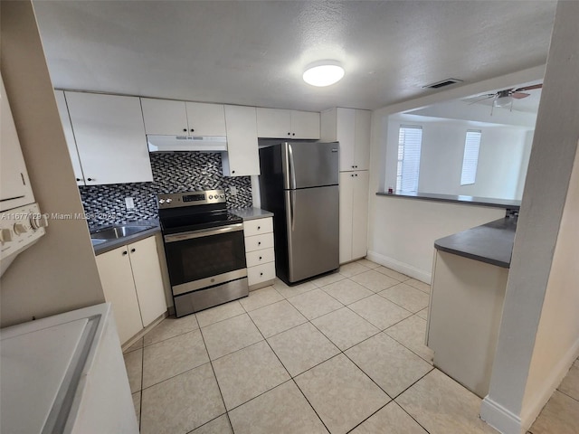 kitchen with ceiling fan, stainless steel appliances, tasteful backsplash, white cabinets, and light tile patterned flooring