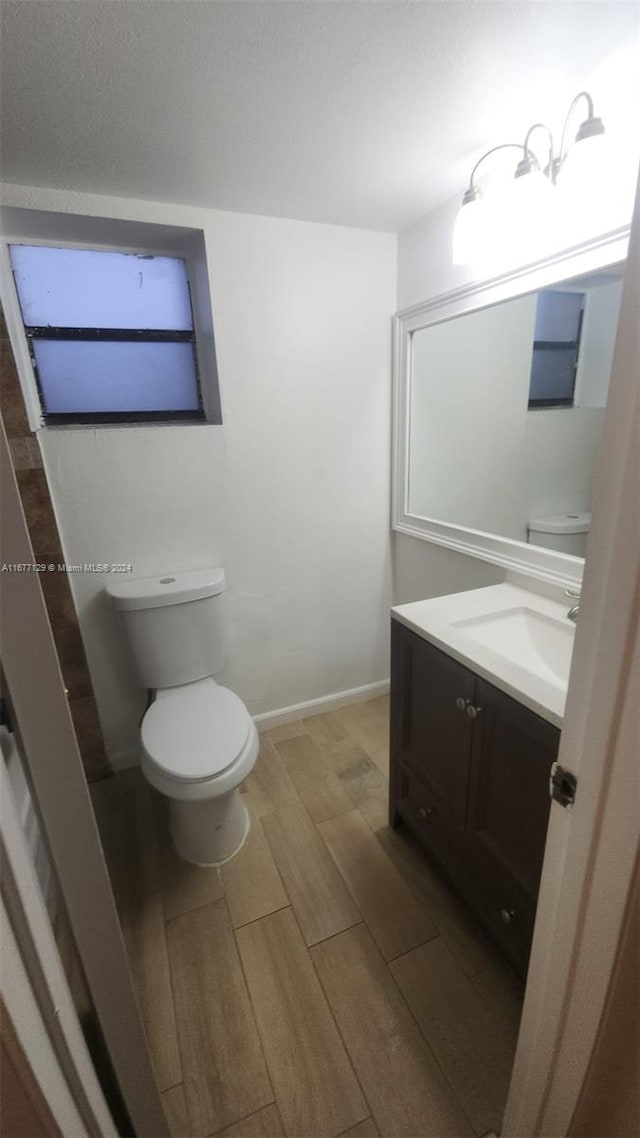 bathroom with vanity, hardwood / wood-style flooring, and toilet