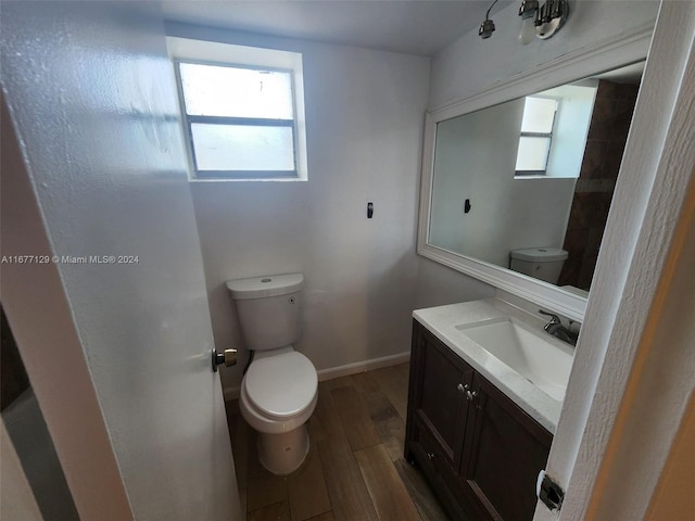 bathroom with vanity, toilet, and hardwood / wood-style floors