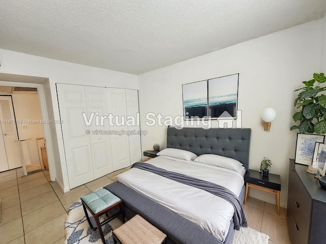 bedroom with light tile patterned floors, a textured ceiling, and a closet