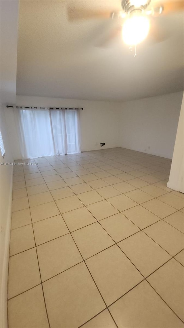 spare room featuring light tile patterned flooring and ceiling fan