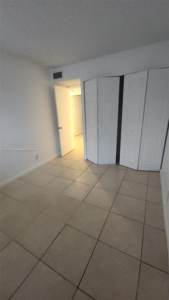 unfurnished bedroom featuring a closet and light tile patterned floors