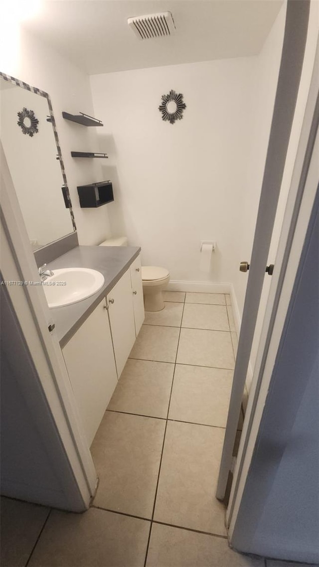 bathroom featuring tile patterned flooring, vanity, and toilet