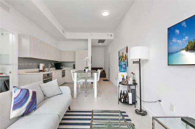 living room featuring sink and light tile patterned floors