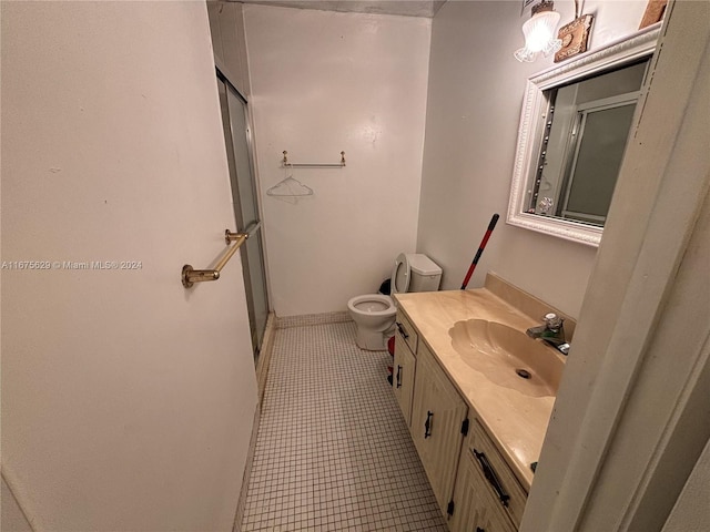 bathroom featuring vanity, a shower with shower door, toilet, and tile patterned floors