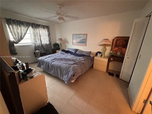 bedroom featuring a closet, light tile patterned flooring, and ceiling fan