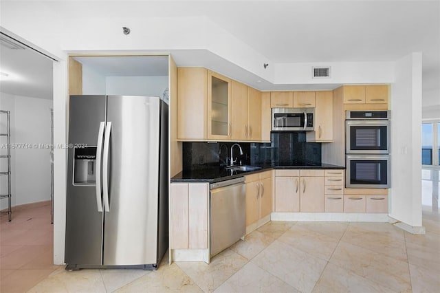 kitchen featuring backsplash, light brown cabinets, sink, and stainless steel appliances