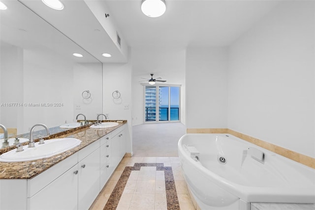 bathroom featuring ceiling fan, tiled tub, and vanity