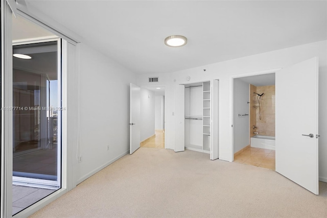 unfurnished bedroom with light carpet and ensuite bathroom