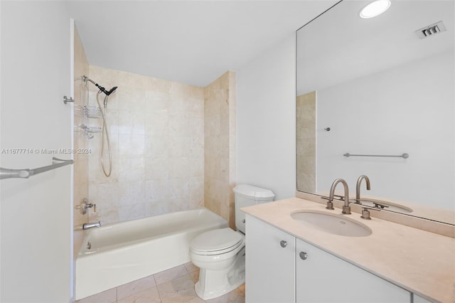 full bathroom with tile patterned flooring, tiled shower / bath combo, toilet, and vanity