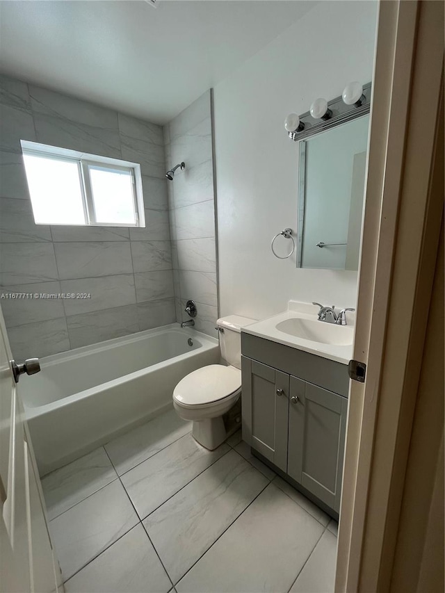 full bathroom featuring vanity, toilet, tiled shower / bath combo, and tile patterned flooring