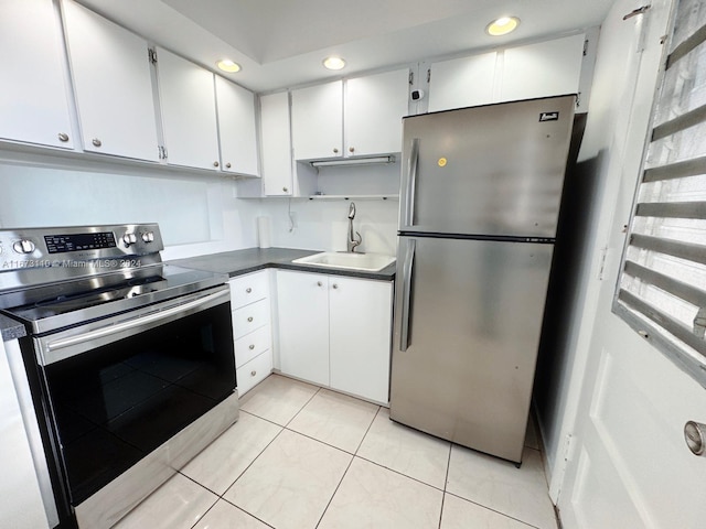 kitchen featuring white cabinetry, sink, light tile patterned flooring, and stainless steel appliances