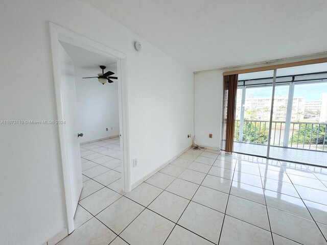 tiled spare room featuring ceiling fan