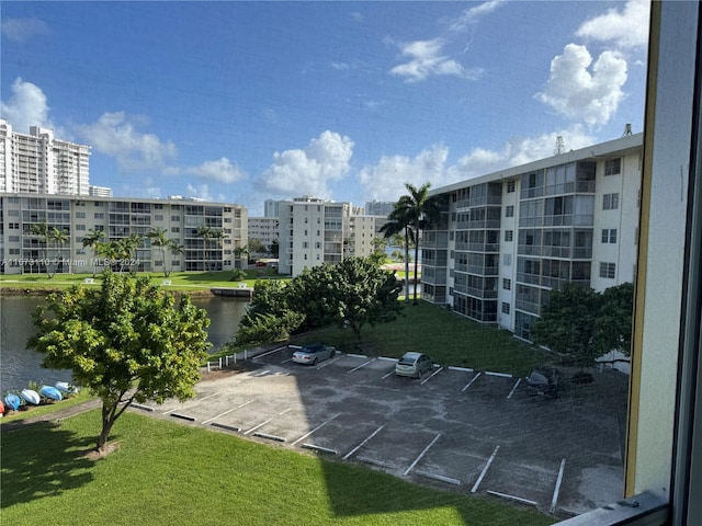 surrounding community featuring a water view and a lawn