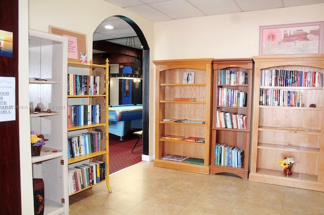 living area with tile patterned flooring and a drop ceiling