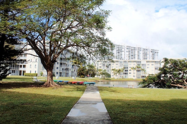 view of community featuring a lawn and a water view