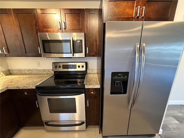 kitchen with stainless steel appliances, light countertops, and dark brown cabinetry