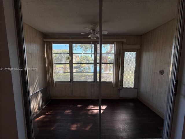 empty room featuring ceiling fan and dark hardwood / wood-style flooring