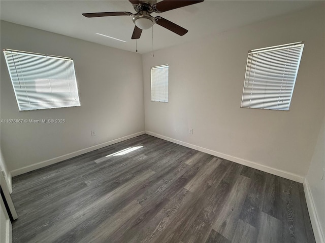 empty room featuring ceiling fan, baseboards, and dark wood finished floors