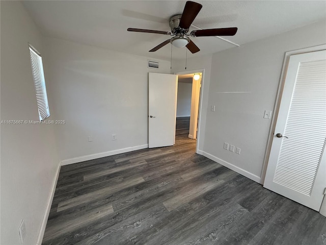 unfurnished bedroom featuring a ceiling fan, dark wood finished floors, visible vents, and baseboards