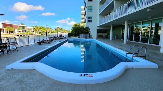 view of pool with a patio area and a water view